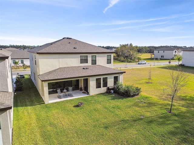 rear view of house with a lawn and a patio