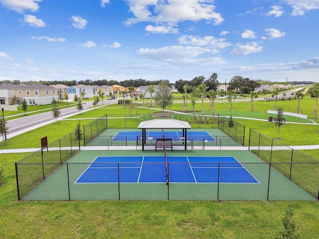 view of tennis court featuring a lawn