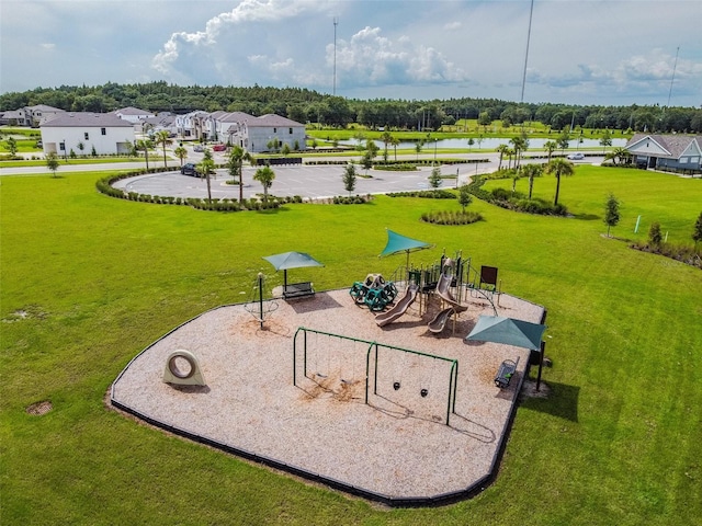 view of community featuring a water view, a playground, and a yard