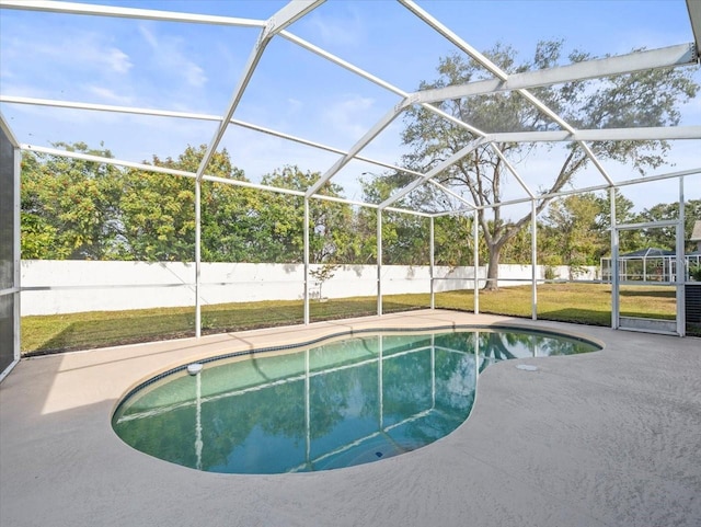 view of pool with a yard, a patio area, and glass enclosure