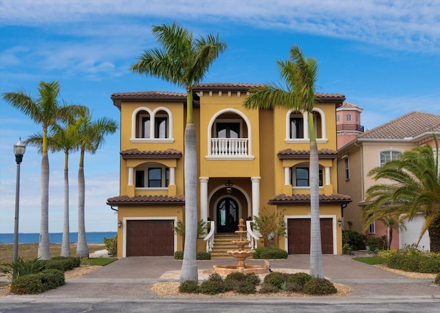 mediterranean / spanish house with a garage and a water view