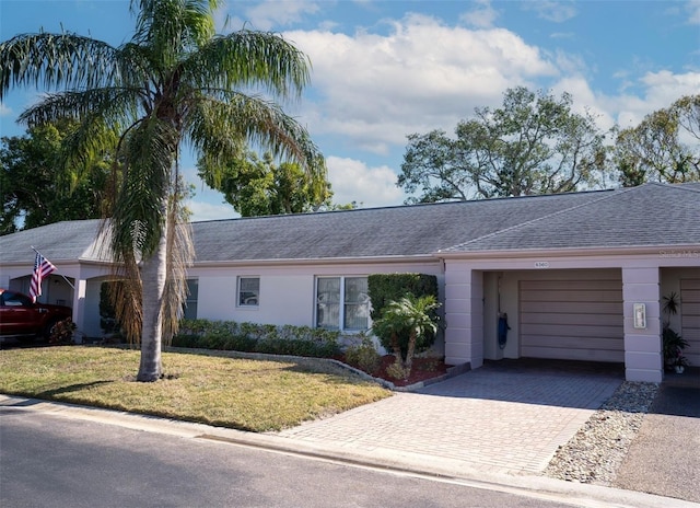 single story home with a garage and a front lawn