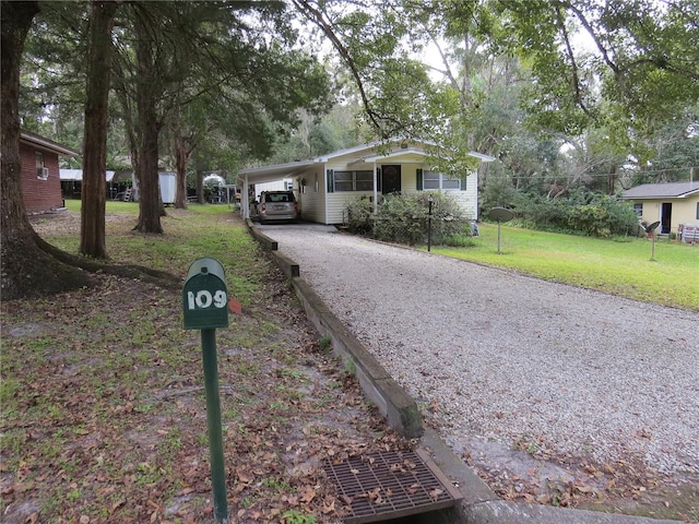 single story home featuring a front lawn and a carport