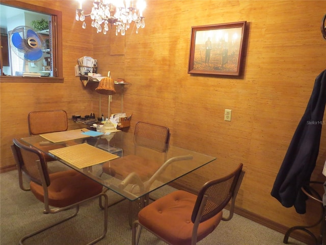 dining space with a notable chandelier and wooden walls