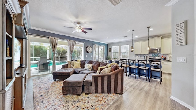 living room with ceiling fan, crown molding, a textured ceiling, and light hardwood / wood-style floors