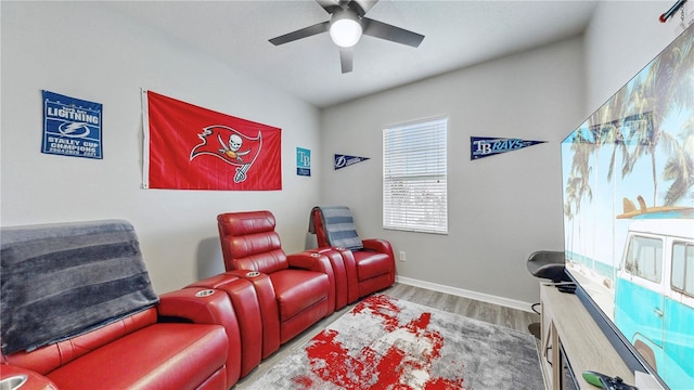 home theater room with ceiling fan and hardwood / wood-style floors