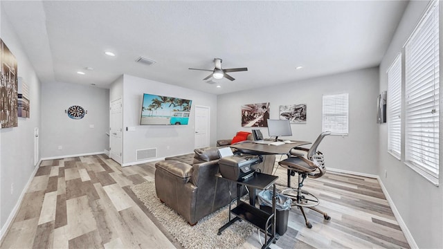 living room with ceiling fan, light wood-type flooring, and plenty of natural light