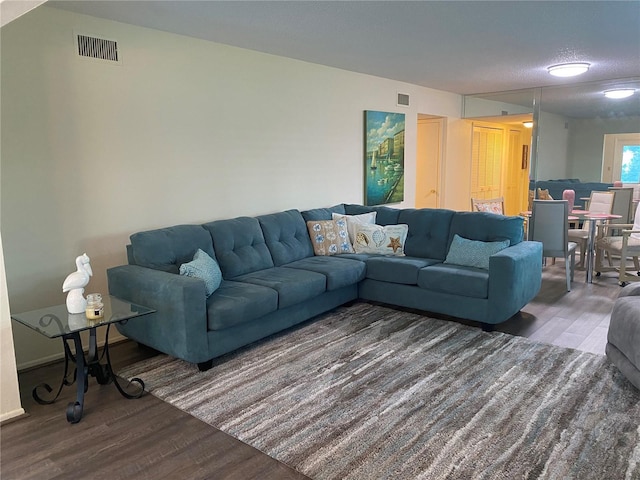 living room featuring a textured ceiling and dark wood-type flooring