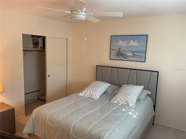 bedroom featuring ceiling fan, a closet, carpet, and a textured ceiling