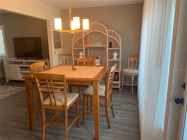 dining area featuring dark hardwood / wood-style flooring and an inviting chandelier