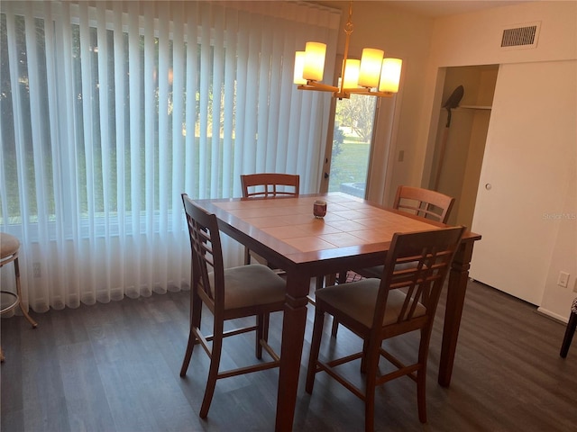 dining area featuring dark hardwood / wood-style floors and a chandelier