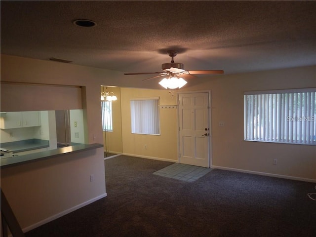 interior space with a textured ceiling and ceiling fan