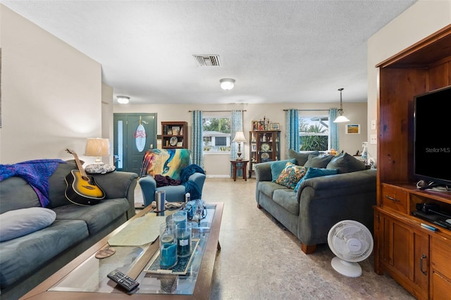 living room featuring a textured ceiling and a healthy amount of sunlight