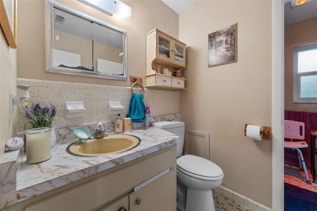 bathroom with toilet, tasteful backsplash, and vanity