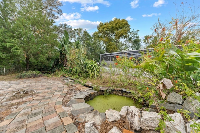 view of yard with glass enclosure and a patio