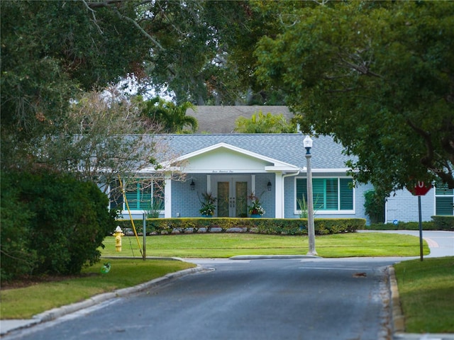 single story home with french doors and a front yard