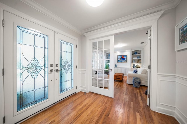 doorway featuring hardwood / wood-style flooring, ornamental molding, french doors, and built in shelves