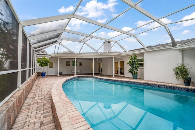 view of swimming pool with glass enclosure and a patio area