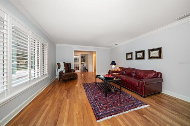 living room with light wood-type flooring, french doors, and crown molding