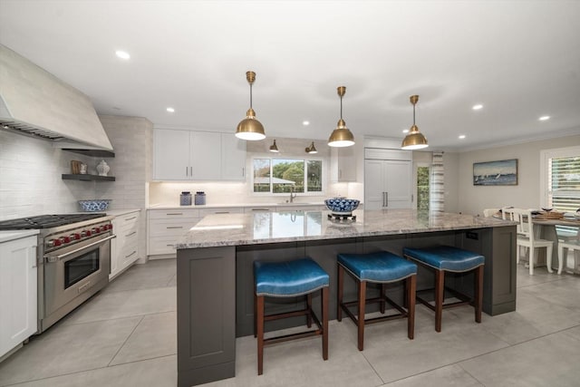 kitchen featuring white cabinets, a center island, and high end appliances