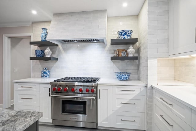 kitchen with designer range, decorative backsplash, and white cabinets