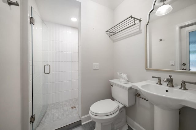 bathroom featuring an enclosed shower, sink, tile patterned floors, and toilet