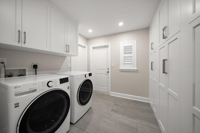 laundry room with washing machine and dryer and cabinets