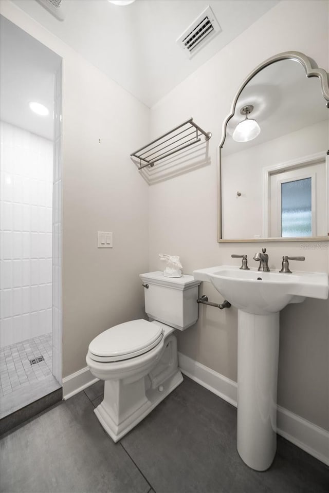 bathroom featuring walk in shower, toilet, and concrete floors