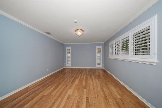 spare room featuring light hardwood / wood-style flooring and crown molding