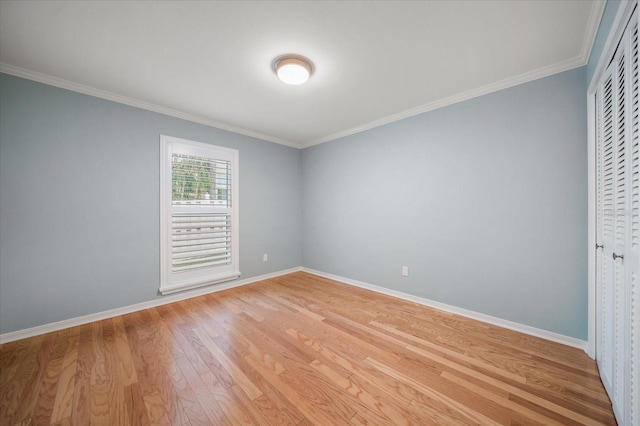 spare room with light hardwood / wood-style floors and crown molding