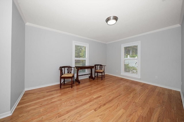 living area featuring light wood-type flooring, ornamental molding, and a healthy amount of sunlight