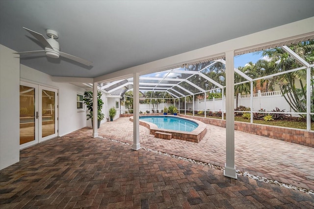 view of swimming pool with glass enclosure, french doors, and a patio