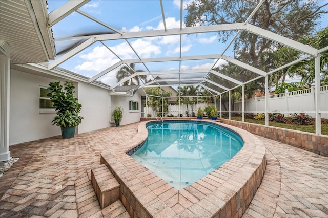 view of swimming pool featuring a lanai and a patio area