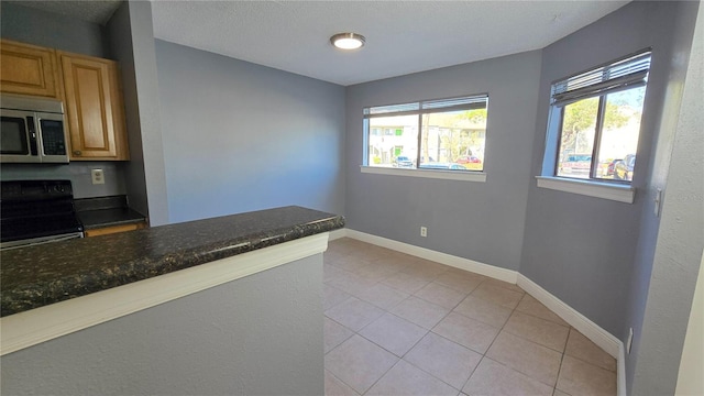 kitchen featuring light tile patterned flooring and electric range