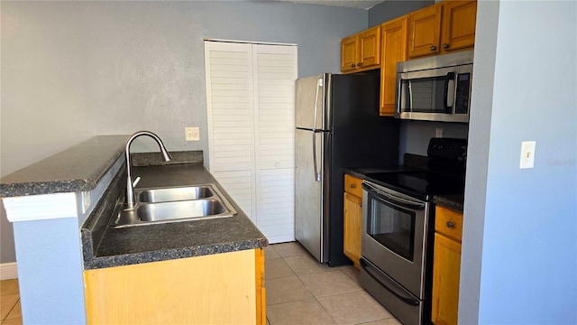 kitchen featuring sink, kitchen peninsula, light tile patterned floors, and stainless steel appliances