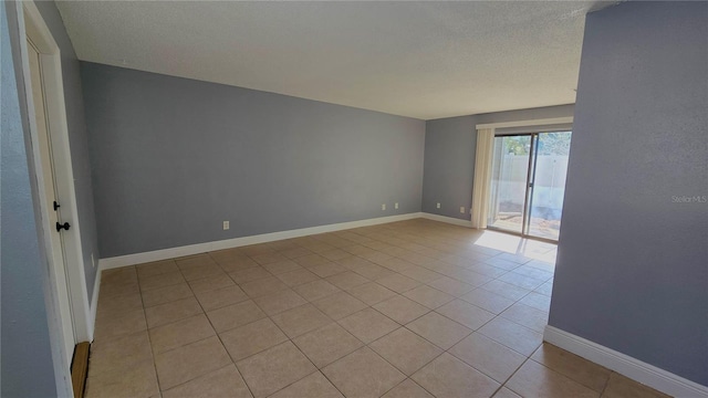 tiled spare room with a textured ceiling