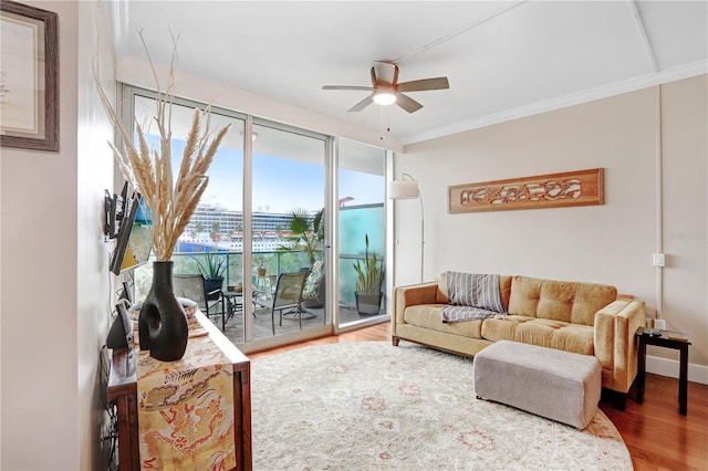 living room featuring ceiling fan, crown molding, and wood-type flooring