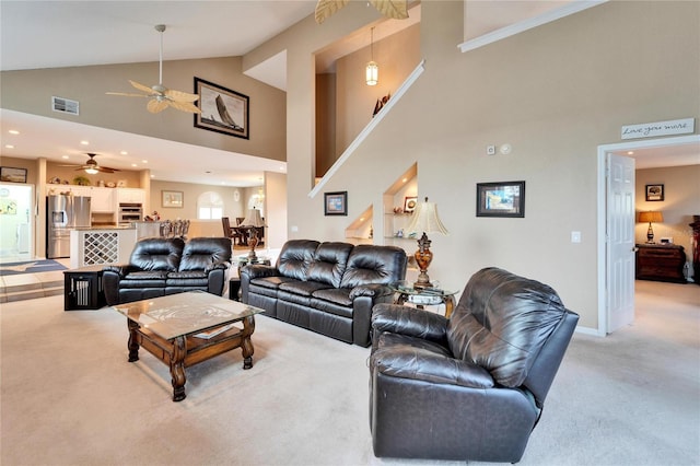 living room featuring ceiling fan, a high ceiling, and carpet floors