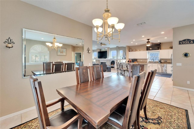 dining area featuring ceiling fan with notable chandelier and light tile patterned flooring