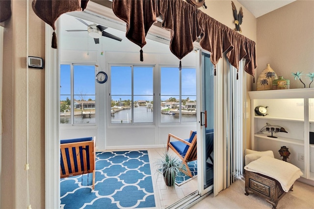 sitting room with ceiling fan, plenty of natural light, and a water view