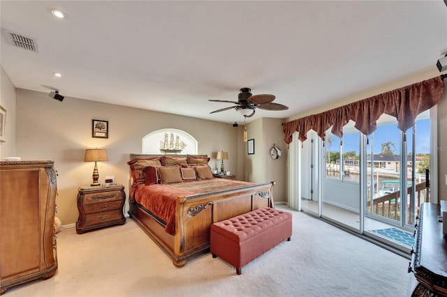 bedroom with access to exterior, ceiling fan, light colored carpet, and multiple windows