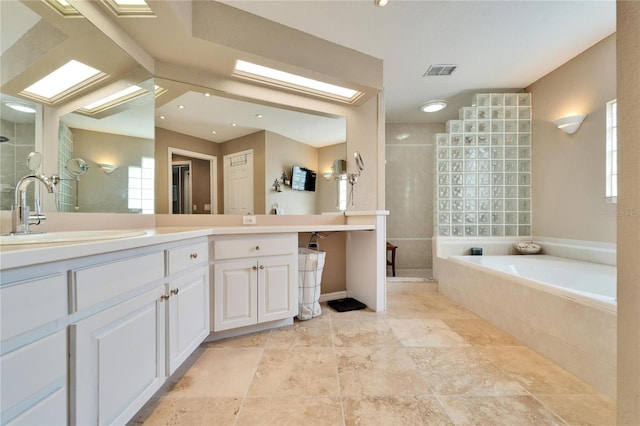 bathroom with vanity, a skylight, and separate shower and tub