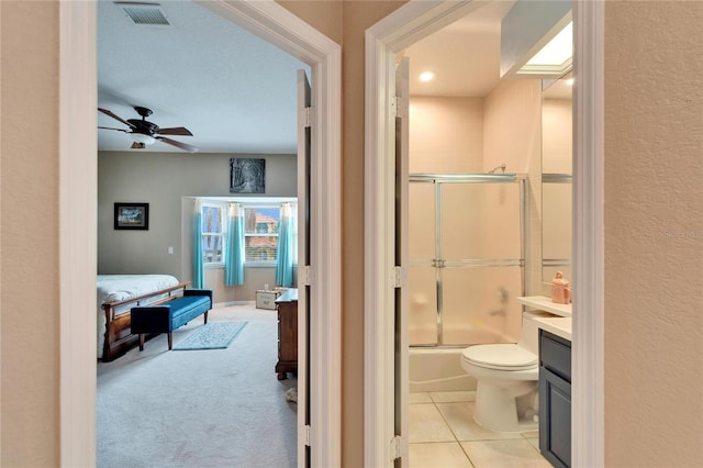 full bathroom featuring toilet, tile patterned flooring, shower / bath combination with glass door, vanity, and ceiling fan