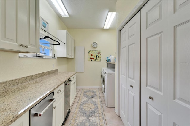 laundry area featuring cabinets, light tile patterned floors, and independent washer and dryer