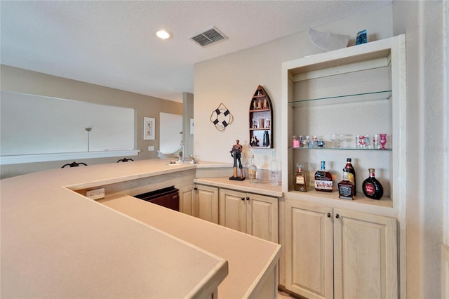 kitchen featuring light brown cabinets and a textured ceiling