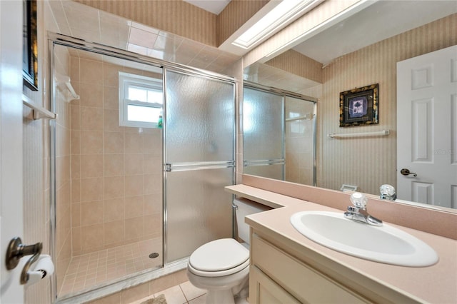 bathroom featuring vanity, toilet, tile patterned floors, and a shower with door