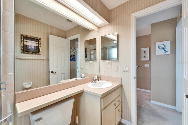 bathroom with vanity, a skylight, and toilet