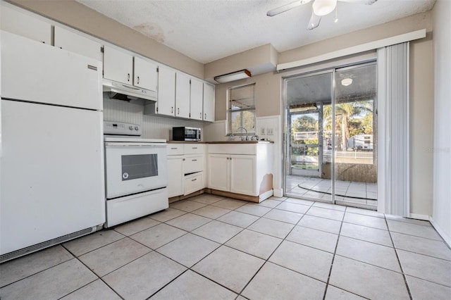 kitchen with ceiling fan, light tile patterned floors, white appliances, a textured ceiling, and white cabinets