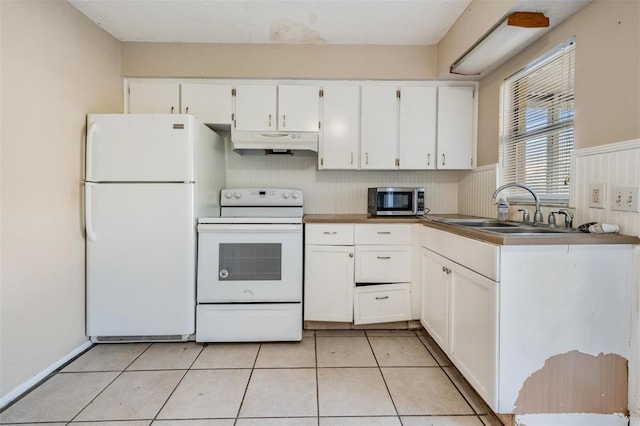 kitchen featuring light tile patterned floors, sink, white appliances, and white cabinetry