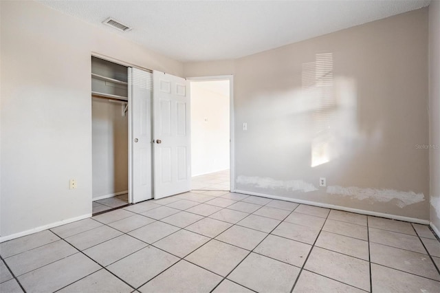 unfurnished bedroom with a closet and light tile patterned flooring